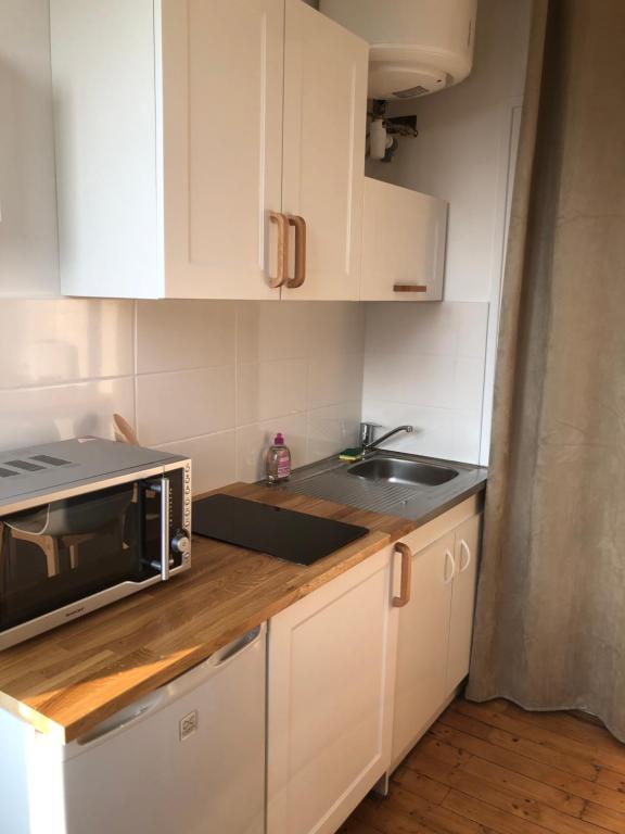 a kitchen with a sink and a microwave at Chez julie in Caen
