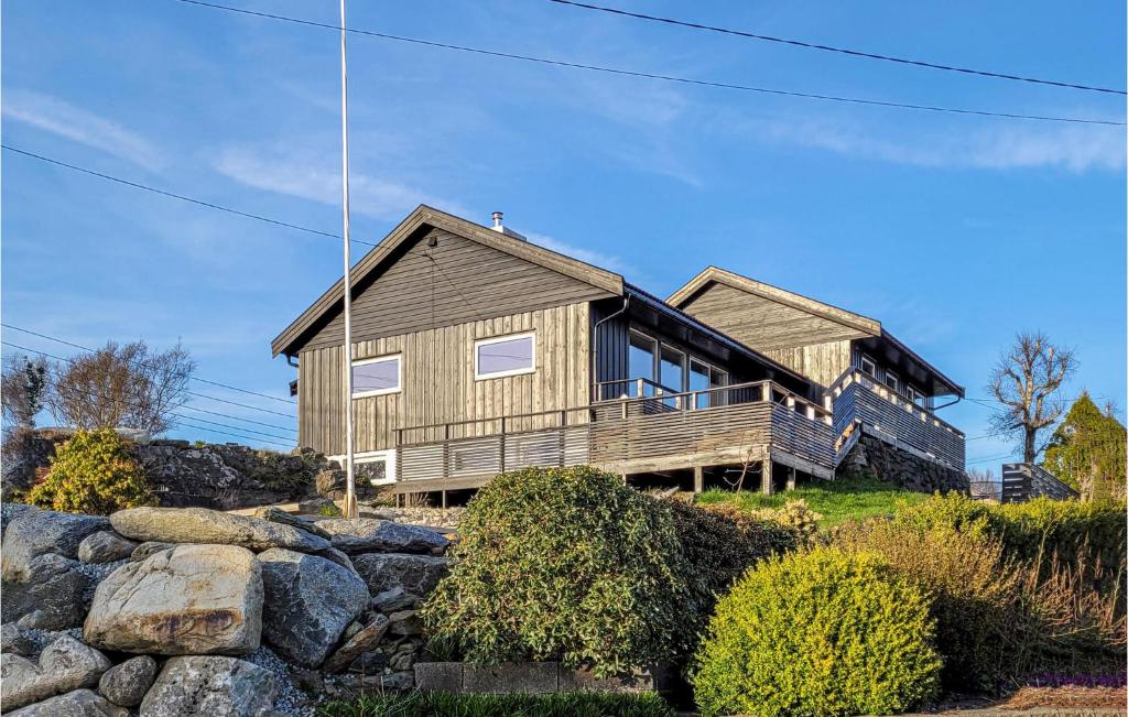 a house on top of a hill with rocks at Nice Home In Hvik With Wifi And 5 Bedrooms 