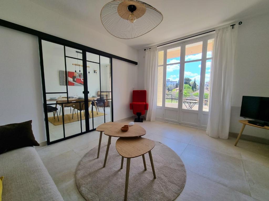 a living room with a table and a couch at Appartement spacieux de standing - parking gratuit in Aix-en-Provence