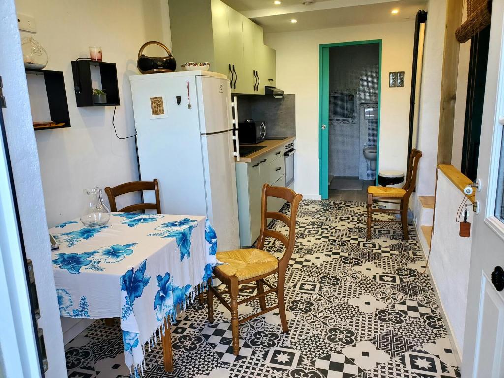 uma cozinha com uma mesa e um frigorífico em Studio 2A em Ucciani