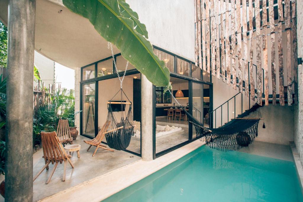 a house with a swimming pool and hammocks on the porch at Round Villa Private Pool & Jungle rooftop 2A in Tulum