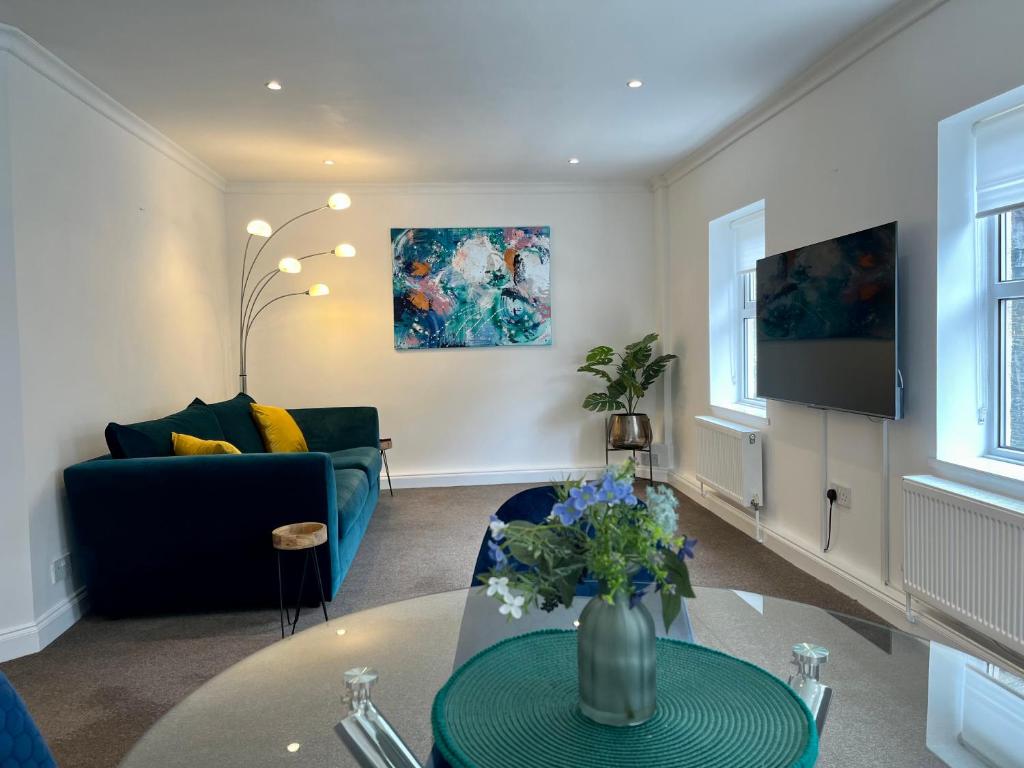 un soggiorno con divano e tavolo di The Apartment, Bridge House a Laxey