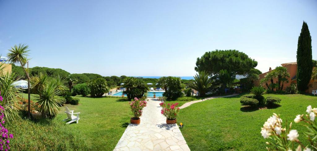 a walkway in a park with plants and flowers at Hôtel les Bouis - Vue mer in Saint-Tropez