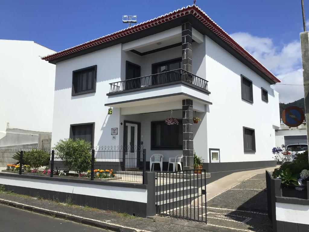 Casa blanca con balcón en una calle en Pousada da Vila en Vila Franca do Campo