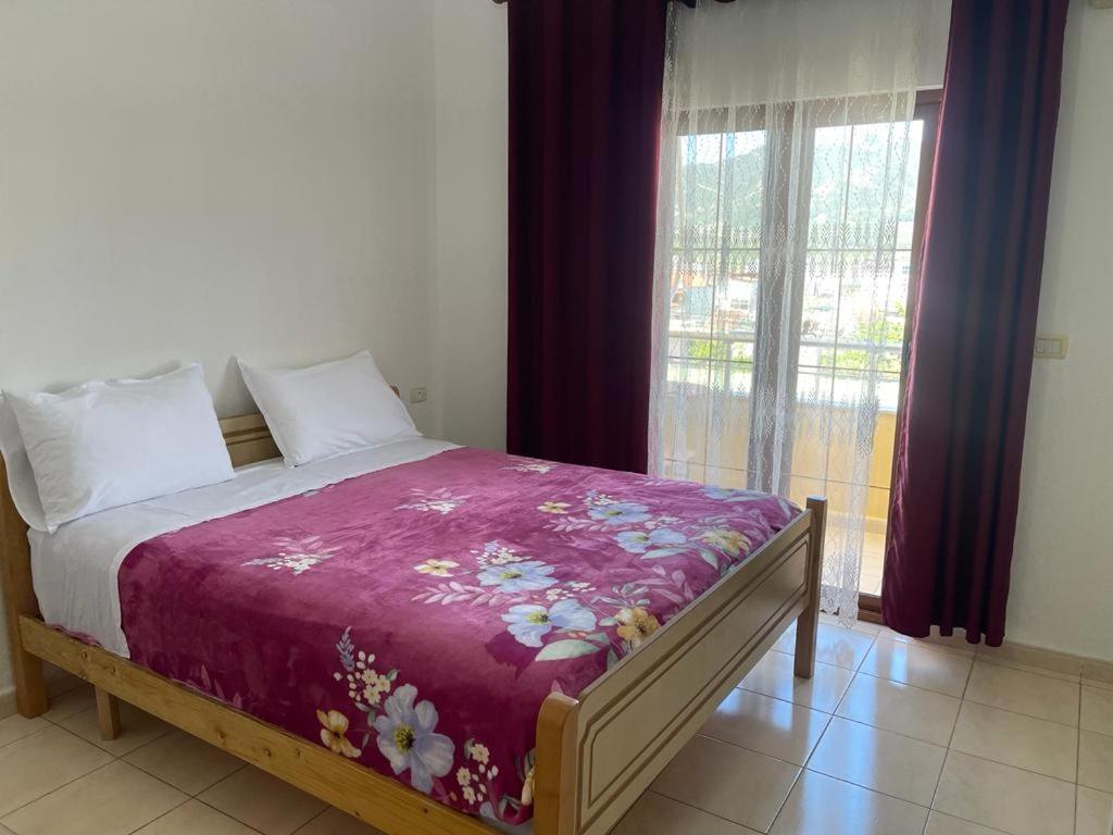 um quarto com uma cama com um cobertor roxo em Maria Guest House em Përmet