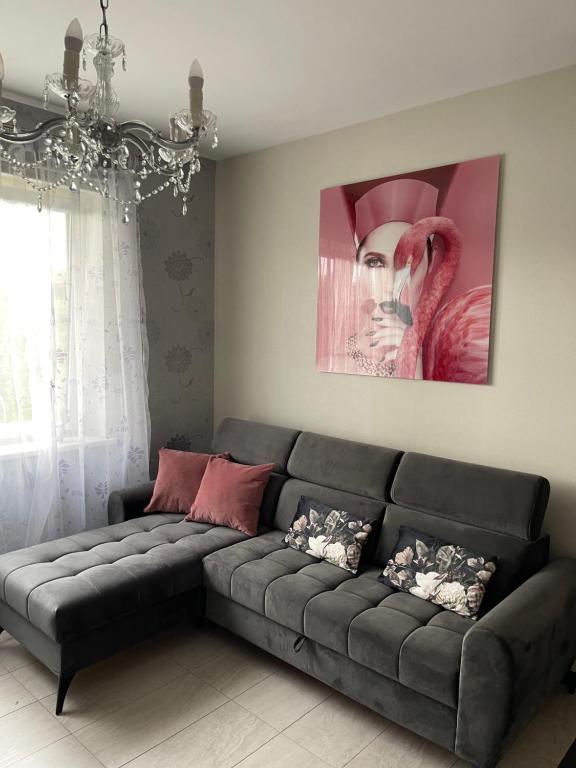 a gray couch in a living room with a painting at Apartment SAMANTA- self-checkin - near Jurmala, airport in Piņķi