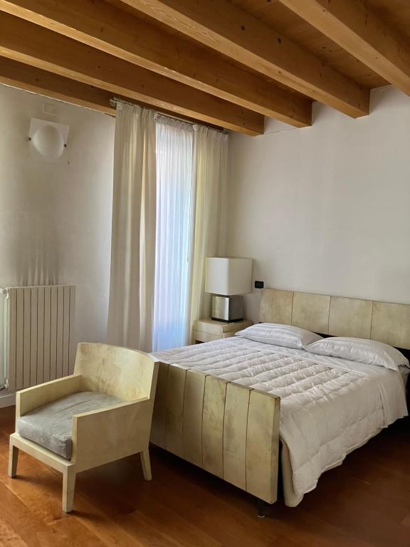 a bedroom with a large bed and a chair at Ciao Amore in Padova