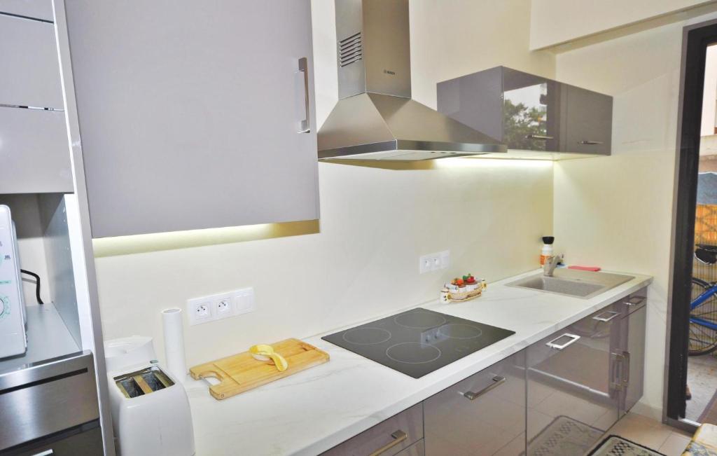 a white kitchen with a stove and a sink at 1 Bedroom Awesome Apartment In Le Cannet in Le Cannet