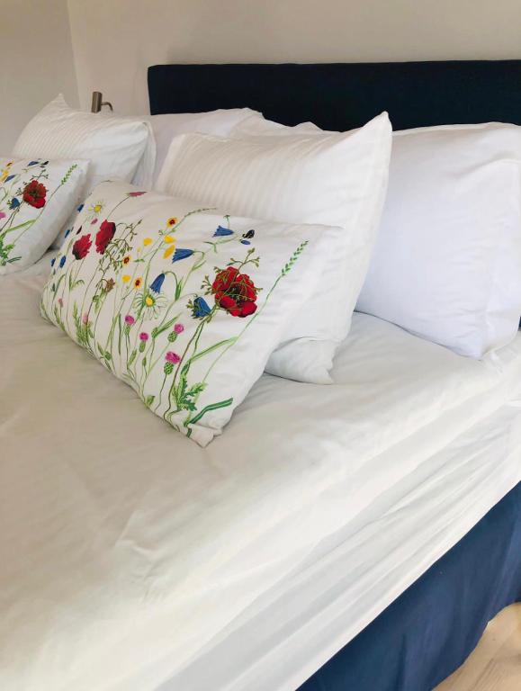 duas almofadas brancas com flores numa cama em Blå Dörren em Torekov