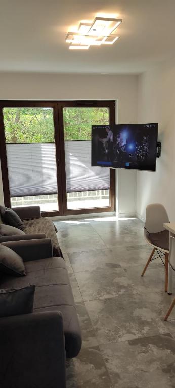 a living room with two couches and a flat screen tv at Apartament Świdnica in Świdnica