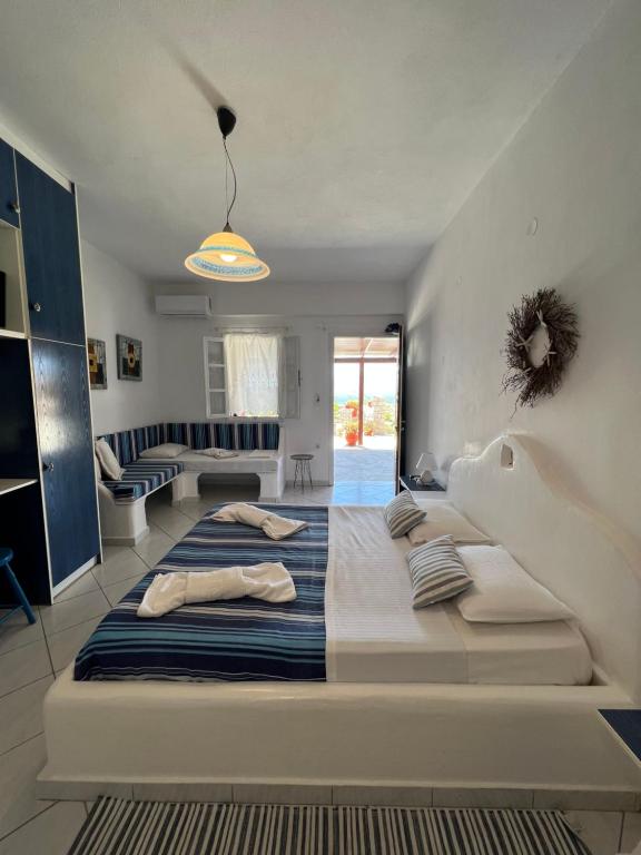a large bed with pillows on it in a room at Christos rooms milos in Adamas