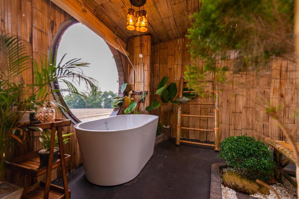 a bath tub in a room with plants at Sky Pruek Cumulus in Mon Jam
