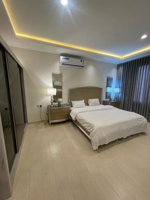 a bedroom with a large white bed in a room at Al Narjes Villas & Apartments in Riyadh