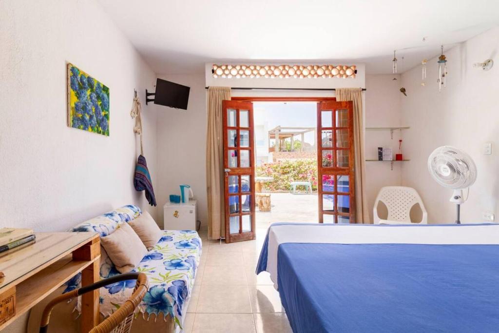 a bedroom with a bed and a couch and a table at Casa Tara in Taganga