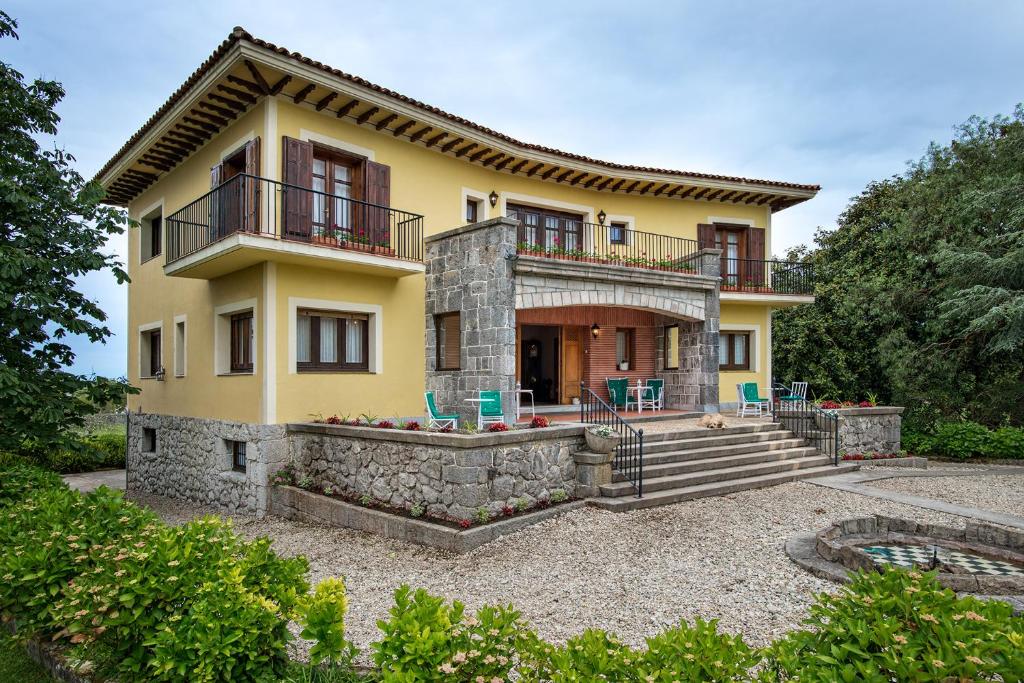 a large yellow house with a balcony on top at Hotel Hontoria in Hontoria