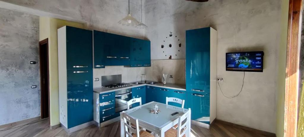 a kitchen with blue cabinets and a table at casa dei gelsi in Bolsena
