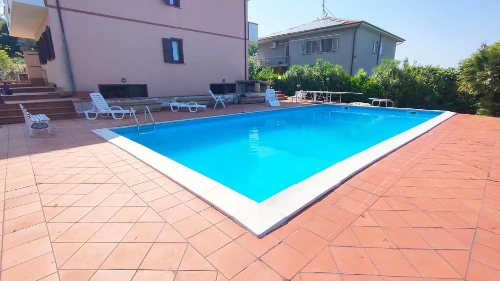 a swimming pool in front of a house at Villa Rosè - Natura vista mare - Narramondo Villas in Cologna