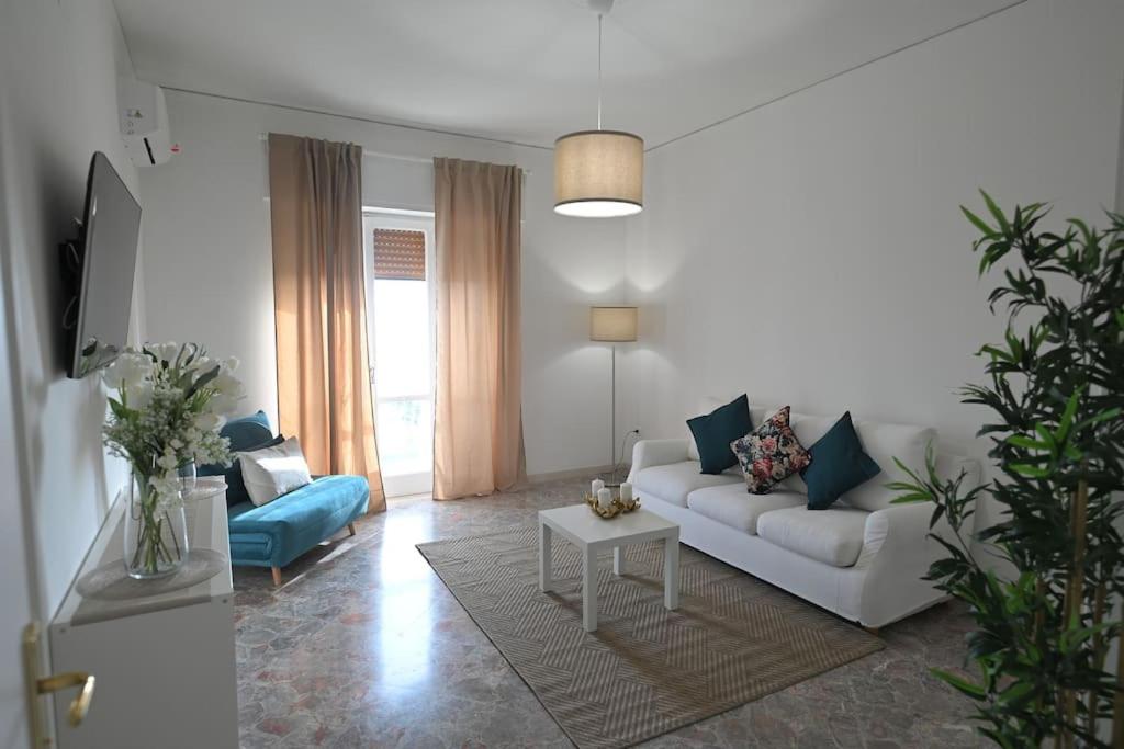 a living room with a white couch and a blue chair at Vista Mare casa vacanze in Torre Annunziata