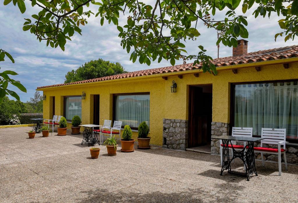a yellow house with a patio with tables and chairs at Hotel Hontoria in Hontoria