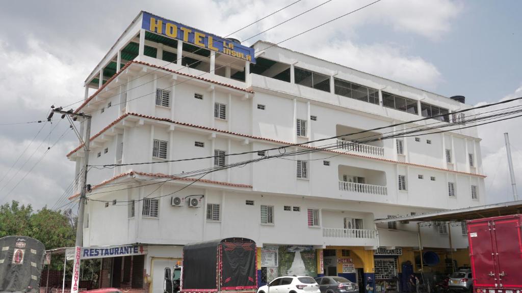 un edificio blanco con un cartel. en Hotel La Ínsula, en Cúcuta