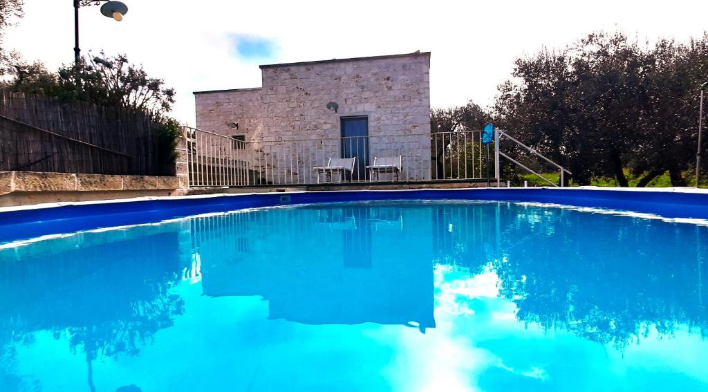 einem Pool mit blauem Wasser vor einem Gebäude in der Unterkunft Lamia Pieranna in Cisternino