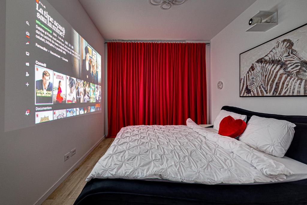 um quarto com uma cama com uma cortina vermelha em ARI Cinema Apartament em Arad