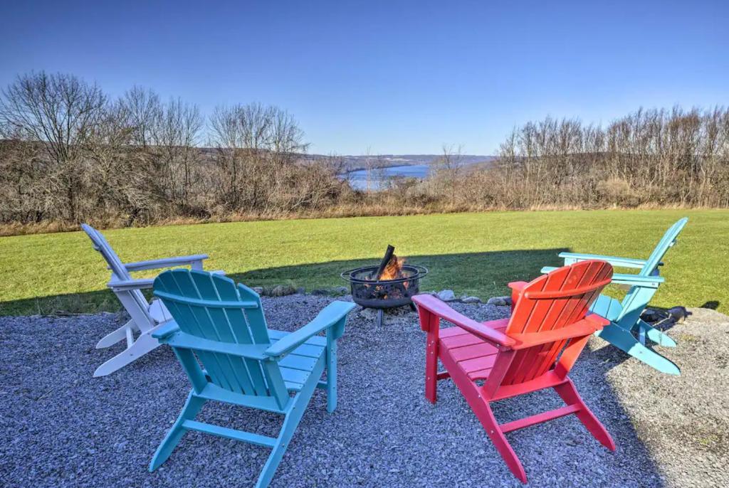three colorful chairs sitting around a fire pit at Hilltop Retreat & Spa in Tully