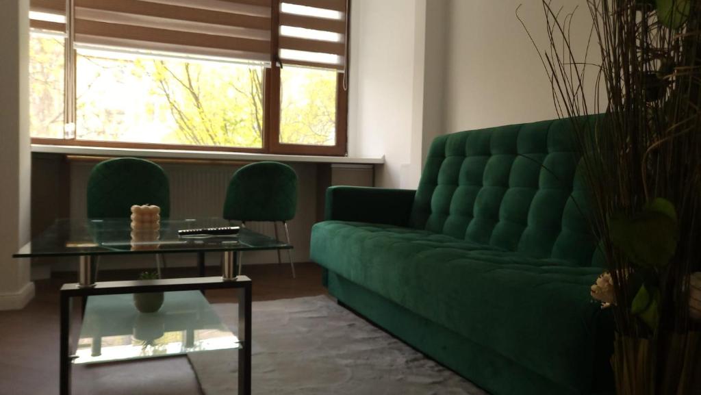 a living room with a green couch and a table at Racosim Residentials in Seleuş