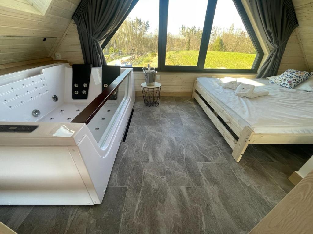 Postel nebo postele na pokoji v ubytování Osada Skoczkowo komfortowe domki z jacuzzi nad jeziorem- sauna- balia- prywatny staw wędkarski