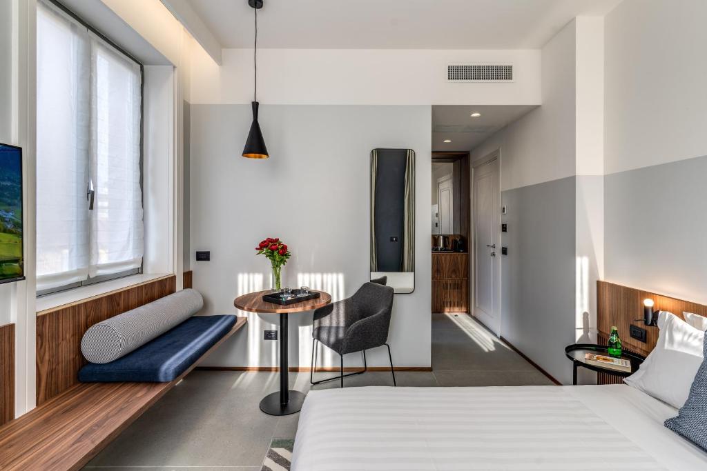 a bedroom with a bed and a table and a tv at Sospeso Boutique Hotel in Milan