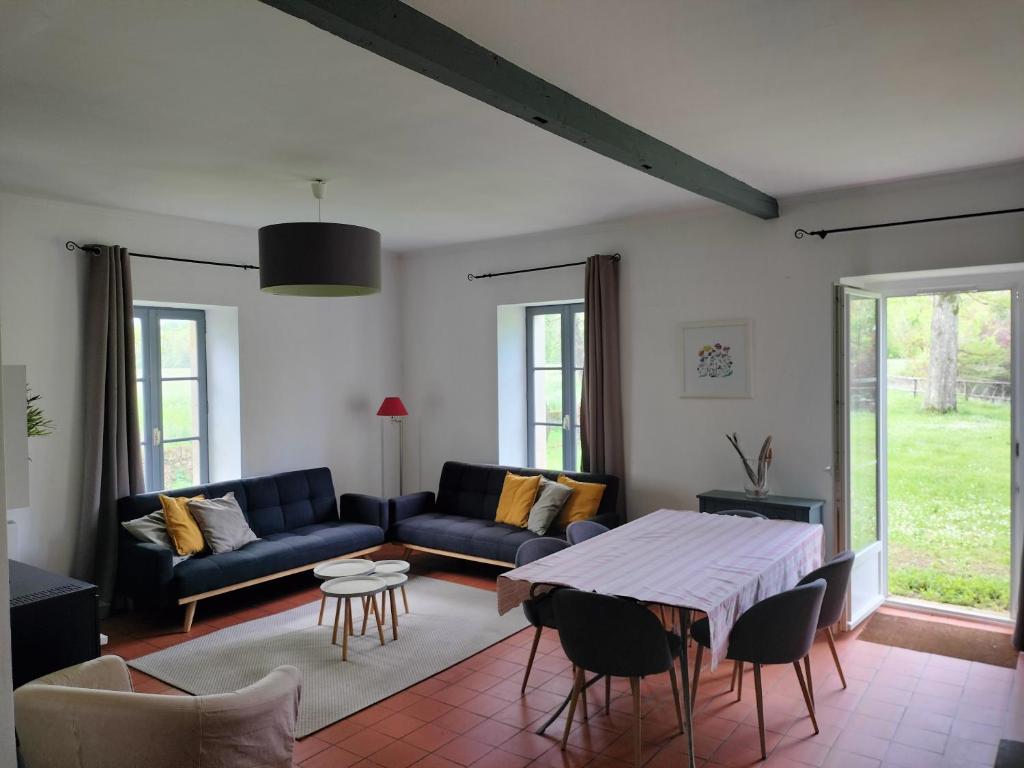 salon z kanapą i stołem w obiekcie Maison de Pierre 4 à 6 personnes w mieście Lempaut