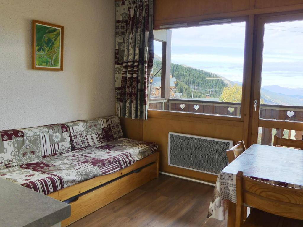 Cette chambre dispose d'un canapé et d'une grande fenêtre. dans l'établissement Petit 2 Pièces avec Balcon à Méribel - FR-1-182-189, à Méribel