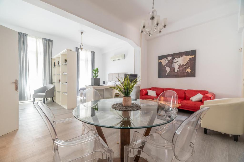 sala de estar con mesa de cristal y sofá rojo en Apollonas Luxurious Apartments en Atenas