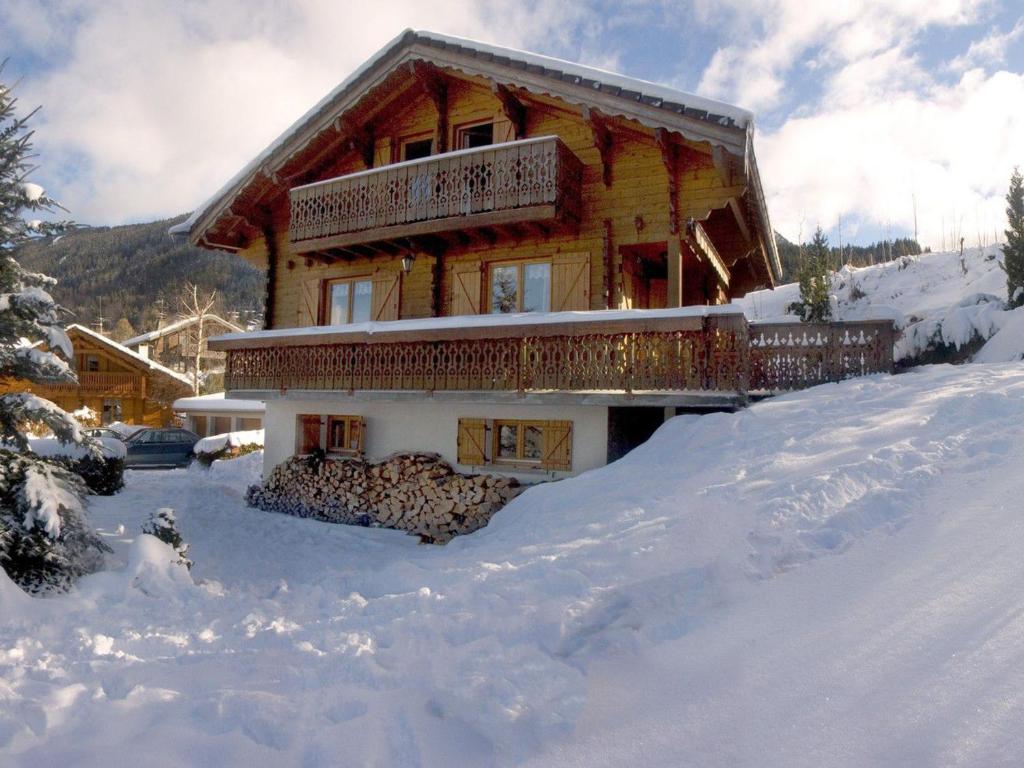 uma cabana de madeira na neve com neve à sua volta em Chalet Les Carroz d'Arâches, 4 pièces, 8 personnes - FR-1-572-243 em Les Carroz d'Arâches