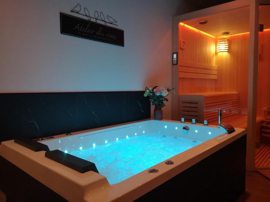 une baignoire jacuzzi dans une chambre avec eau bleue dans l'établissement Elo Spa, à Saint-Quentin