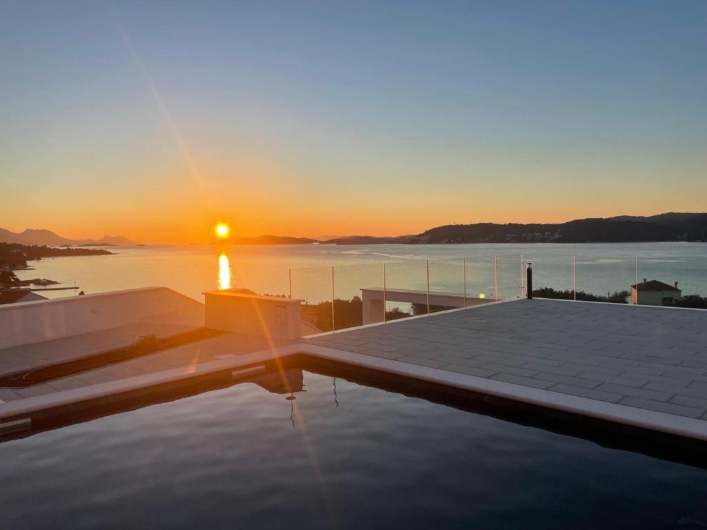a sunset on the roof of a house with a swimming pool at Villa Bofor in Kučište