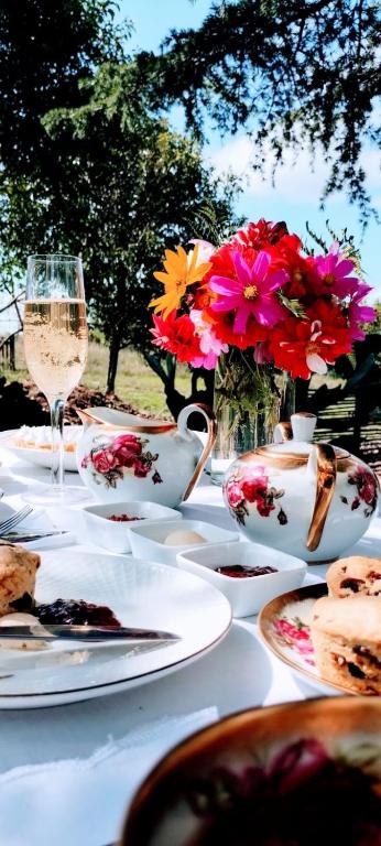a table with plates of food and a glass of wine at La Flor del Camino Posada in Tanti