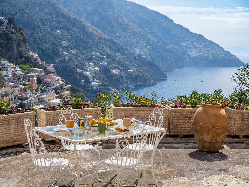 a table and chairs on a balcony with a view at Rosa House - Breathtaking View of the Amalfi Coast in Positano