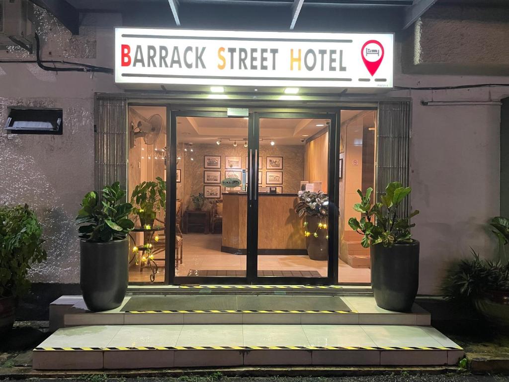 a barack street hotel with potted plants in front of it at Barrack Street Hotel in Taiping