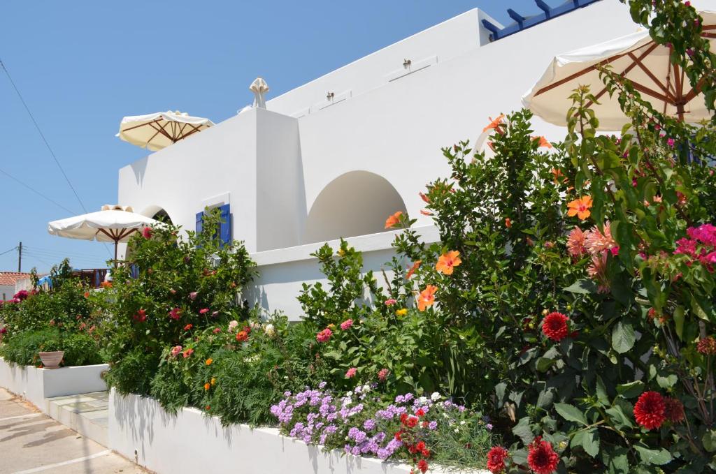 a garden in front of a white building with flowers at Maryianni Apartments in Avlemonas