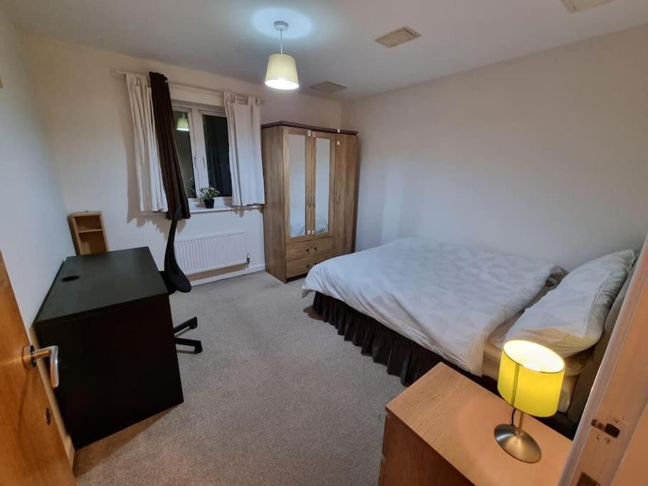 a bedroom with a bed and a desk and a window at Laura's Place in Isleworth