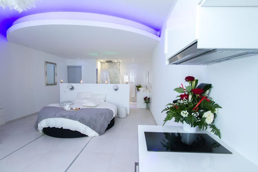 Dieses weiße Zimmer verfügt über ein Bett und einen TV. in der Unterkunft Love Loft in Bordeaux