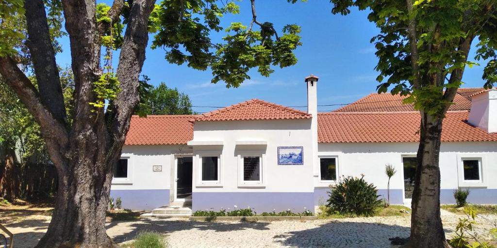 une maison blanche avec un toit rouge dans l'établissement Casa de Arcos, à Anadia