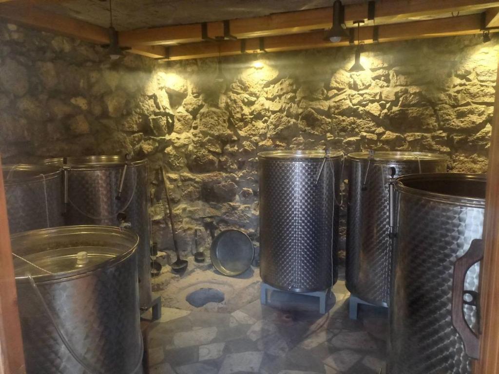 a row of metal trash cans against a stone wall at Yeganyans Guest House and Wine Yard in Ashtarak
