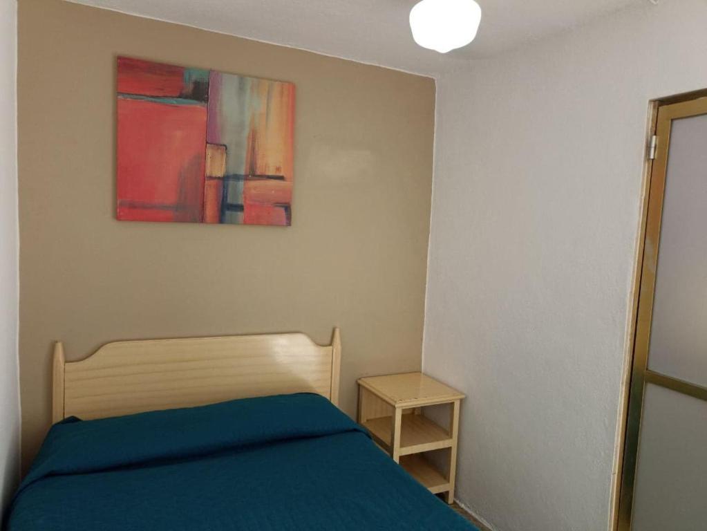 1 dormitorio con 1 cama y una pintura en la pared en Hotel Metropolitan II, en Irapuato