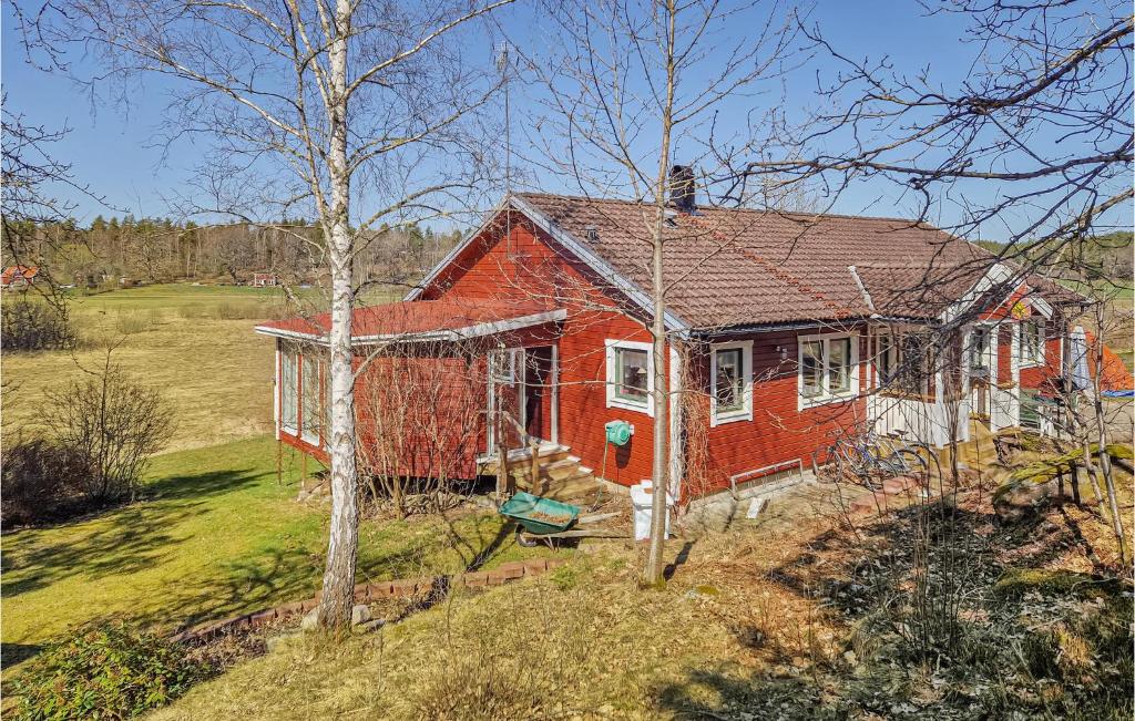 una casa roja y blanca en medio de un campo en Pet Friendly Home In Valdemarsvik With Wifi en Valdemarsvik