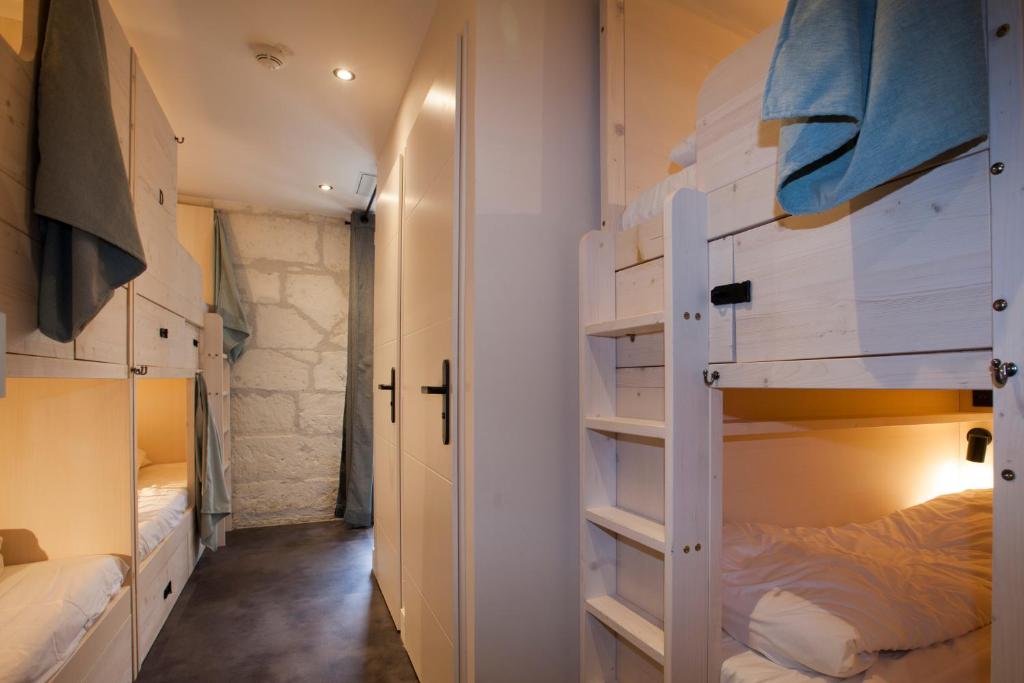 a room with two bunk beds and a hallway at Le Maje Hostel in Montpellier