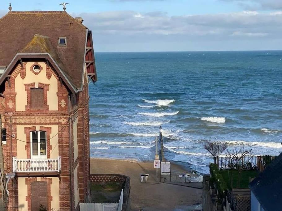 un edificio en la playa junto al océano en Le petit charmeur en Houlgate
