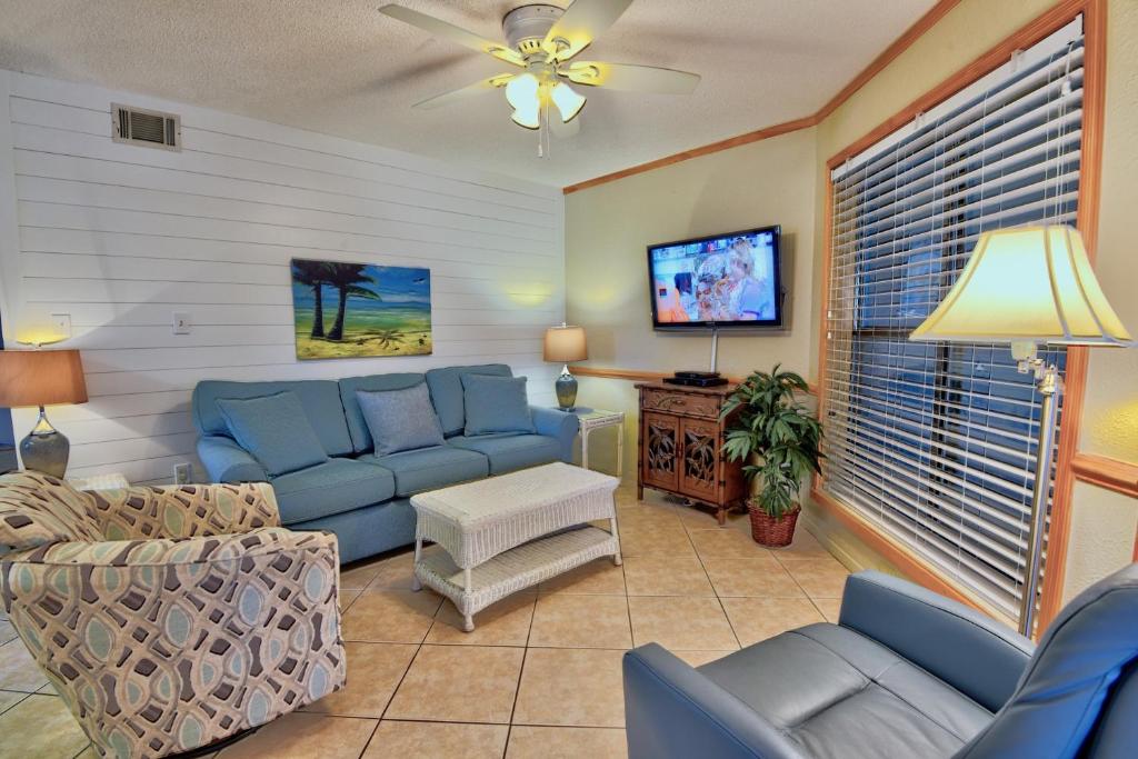 een woonkamer met blauwe banken en een tv bij Sandpiper 1A in Gulf Shores