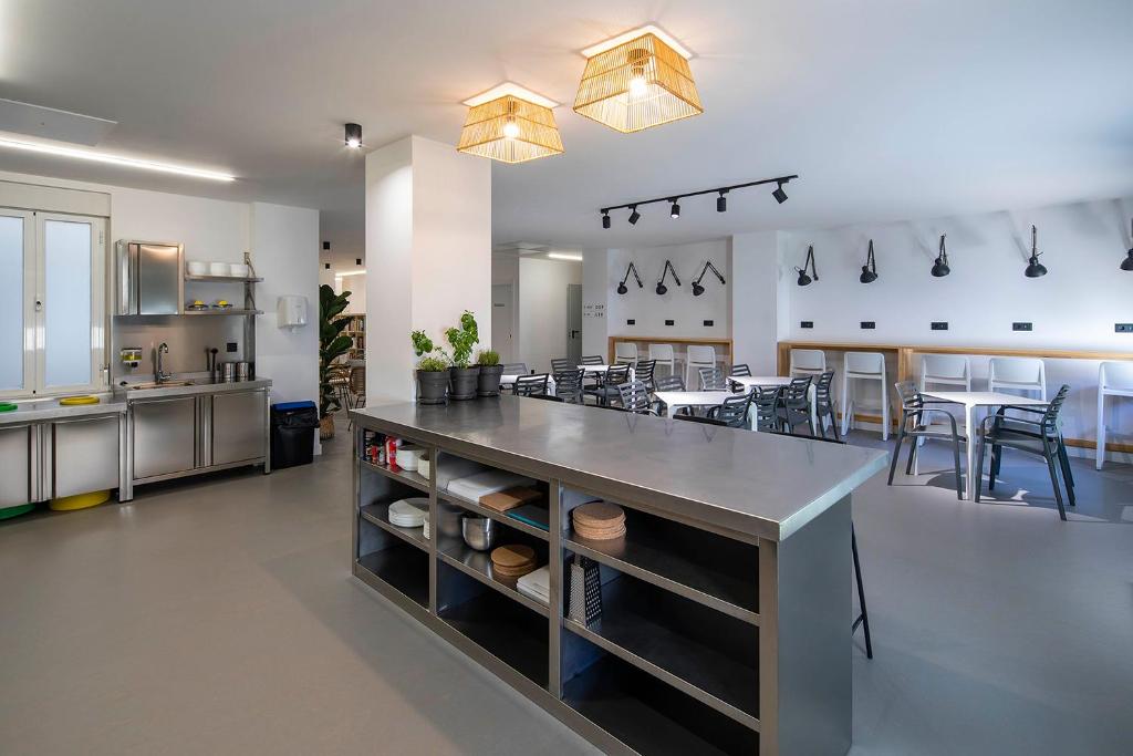 ポンテベドラにあるBulezen Urban Hostelの大きなキッチン(椅子付きの大きなカウンター付)